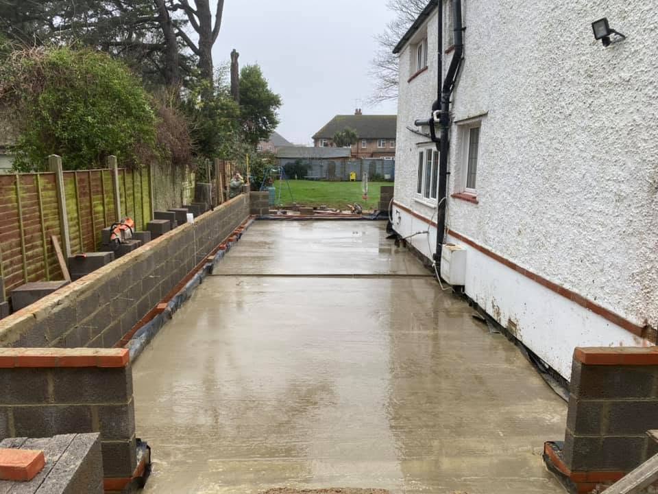 Residential groundworks site with completed foundations and drainage installation in West Sussex
