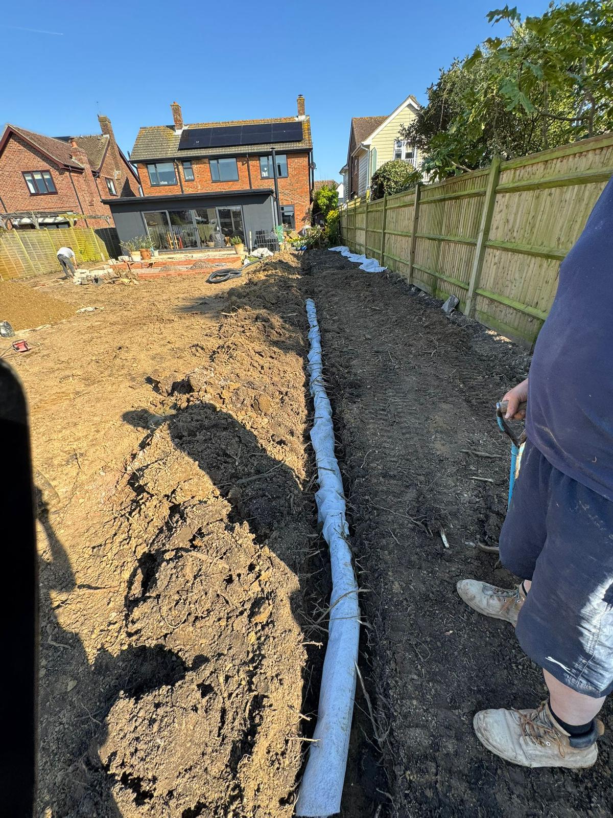 Land drainage pipe being installed in garden West Sussex