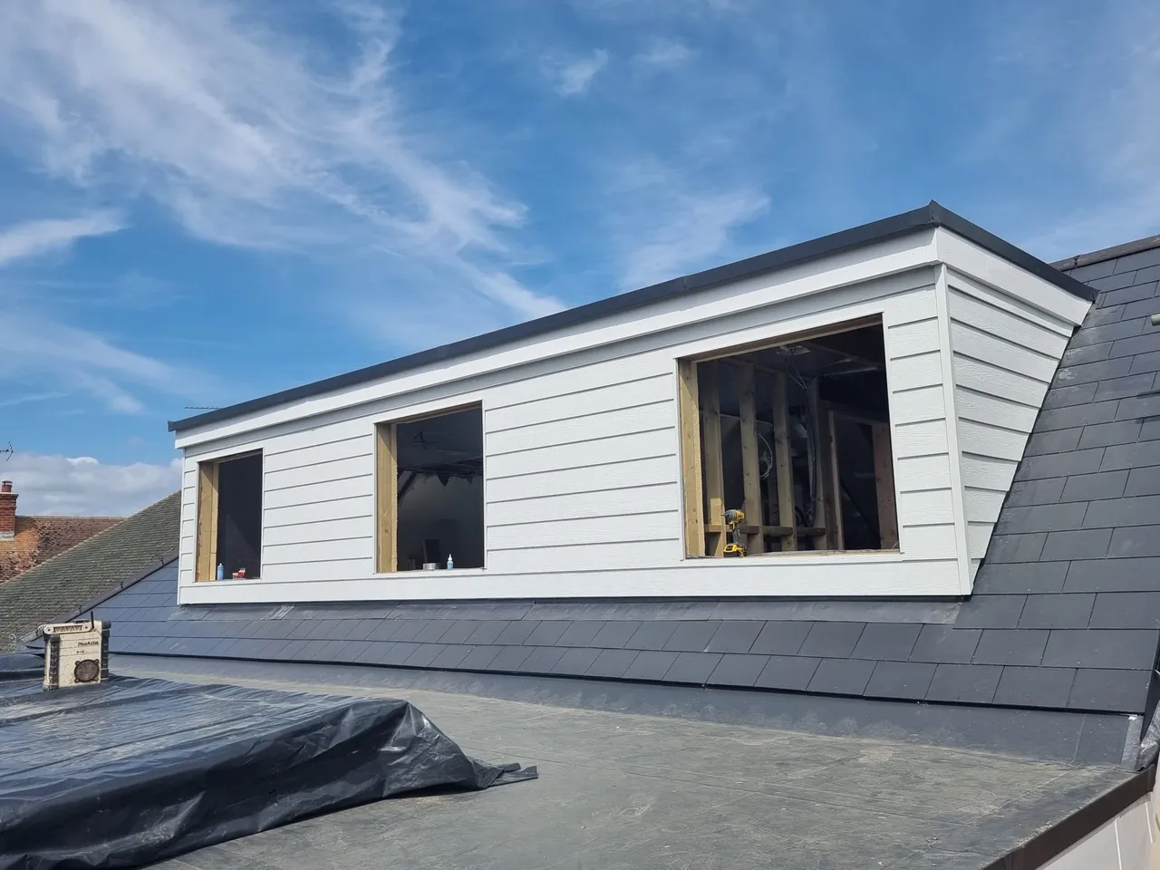 Bright dormer loft conversion with a finished bedroom and large windows in West Sussex